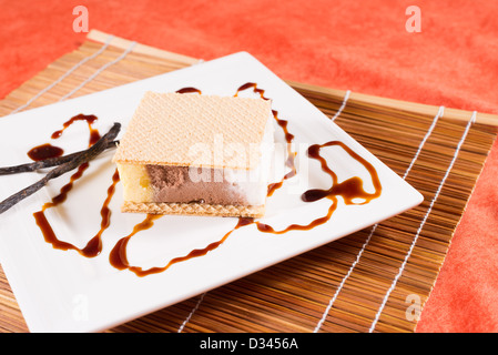 Teil von Ice Cream Sandwich serviert mit Karamell-Sirup und Zimt Stockfoto