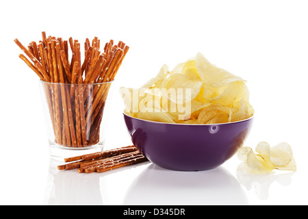 Kartoffel-Chips in einer Schüssel mit Brezel sticks in einem Glas auf weißem Hintergrund Stockfoto