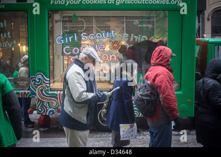 Unerschrockene Girl Scout Cookie-Liebhaber mutig das Winterwetter in Zeile bis zu kaufen Cookies auf Girl Scout Cookie Nationalfeiertag in New York Stockfoto