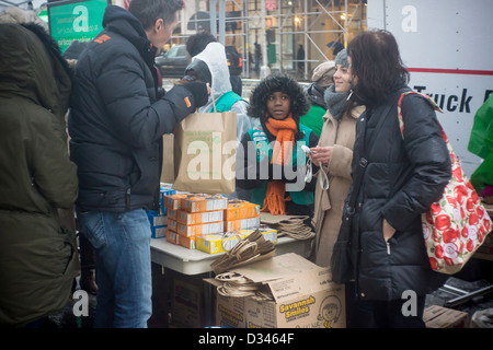 Unerschrockene Girl Scout Cookie-Liebhaber mutig das Winterwetter in Zeile bis zu kaufen Cookies auf Girl Scout Cookie Nationalfeiertag in New York Stockfoto