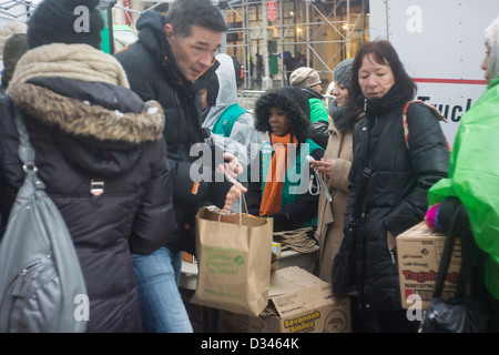 Unerschrockene Girl Scout Cookie-Liebhaber mutig das Winterwetter in Zeile bis zu kaufen Cookies auf Girl Scout Cookie Nationalfeiertag in New York Stockfoto