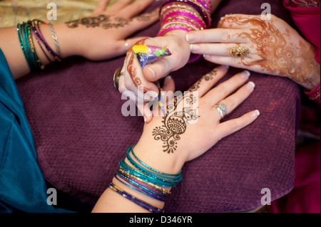 Künstler Anwendung Pfau Henna Design zu einer Frauenhand Stockfoto