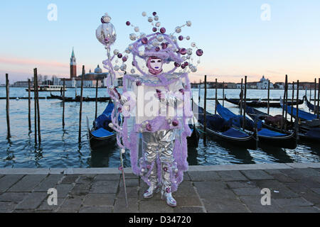 Venedig, Italien. 8. Februar 2013. Wie die Sonne zu setzen beginnt, beginnen die schönen Menschen von der Karneval von Venedig, auf der Uferpromenade in ihren Kostümen und Masken zu posieren für Fotos vor der Insel San Giorgio Maggiore zu migrieren. Das Thema für das Jahr 2013 ist Live in Farbe. Bildnachweis: Paul Brown / Alamy Live News Stockfoto