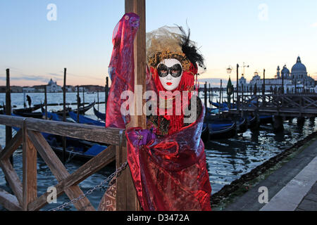 Venedig, Italien. 8. Februar 2013. Wie die Sonne zu setzen beginnt, beginnen die schönen Menschen von der Karneval von Venedig, auf der Uferpromenade in ihren Kostümen und Masken zu posieren für Fotos vor der Insel San Giorgio Maggiore zu migrieren. Das Thema für das Jahr 2013 ist Live in Farbe. Bildnachweis: Paul Brown / Alamy Live News Stockfoto