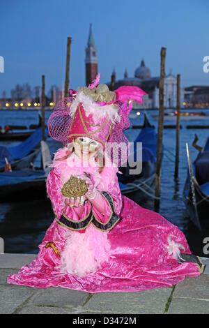 Venedig, Italien. 8. Februar 2013. Wie die Sonne zu setzen beginnt, beginnen die schönen Menschen von der Karneval von Venedig, auf der Uferpromenade in ihren Kostümen und Masken zu posieren für Fotos vor der Insel San Giorgio Maggiore zu migrieren. Das Thema für das Jahr 2013 ist Live in Farbe. Bildnachweis: Paul Brown / Alamy Live News Stockfoto