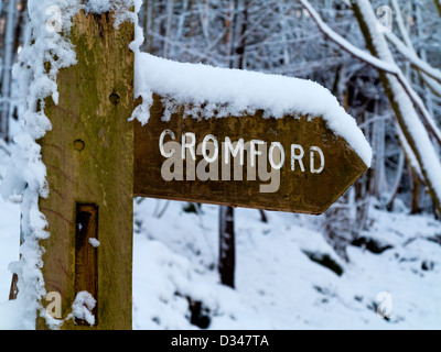 Schnee bedeckten hölzernen Wegweiser mitten im Winter auf dem Höhenweg Peak in der Nähe von Cromford Derbyshire Dales Peak District England UK Stockfoto