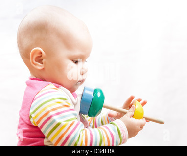 Kleine trauriges braune Augen Baby spielt mit Holzspielzeug, Studioportrait Profil Stockfoto