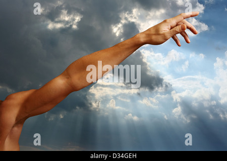 Die Hand des Mannes auf einem Hintergrund des Himmels Stockfoto