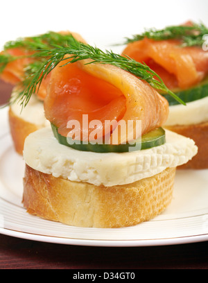 Kanapees mit geräuchertem Lachs, Käse und Gurken. Nahaufnahme Stockfoto