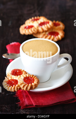 Tasse Kaffee und süßes Gebäck auf einem dunklen Hintergrund. Stockfoto