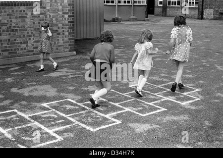 Grundschule Spielplatz Hoppscotch Hop scotch. Mädchen spielen zusammen. South London. 1970s Großbritannien. Das junge Mädchen links trägt einen Augenfleck. HOMER SYKES Stockfoto