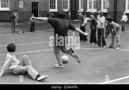 Grundschule Spielplatz. Jungen Fußball spielen. Südlondon. 1970er Jahren Großbritannien. HOMER SYKES Stockfoto