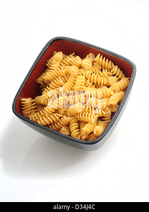eine Schüssel mit Nudeln Rotelli in roten Schüssel auf weißem Hintergrund Stockfoto