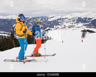 Zwei männliche Skifahrer in diffusem Licht auf rote laufen Marmotte in Le Grand Massif Skifahren Skigebiet der französischen Alpen über Samoëns Resort, Frankreich Stockfoto