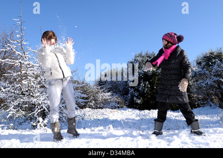 mit einer Tochter im Schnee spielen Stockfoto