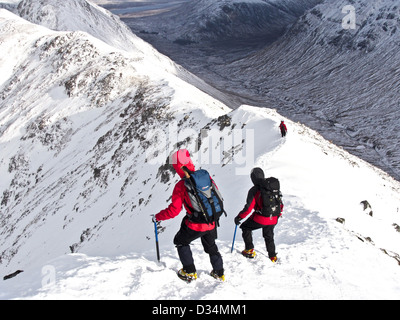 Zwei Winter Bergsteiger absteigend einen Grat auf dem schottischen Berg Buachaille Etive Beag in Glencoe in s, Schottland, Vereinigtes Königreich Stockfoto