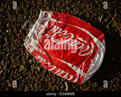 Auf einer Straße der Stadt liegt eine zerquetschte und entsorgte Coca-Cola-Dose, die den städtischen Müll und die Umweltauswirkungen von Einwegverpackungen in öffentlichen Räumen symbolisiert Stockfoto