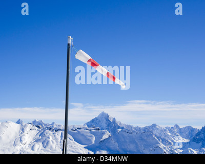 Windsack an einem windigen Tag im Les Grandes Platieres in Le Grand Massif mit Blick auf schneebedeckte Berge in Französische Alpen Frankreich Stockfoto