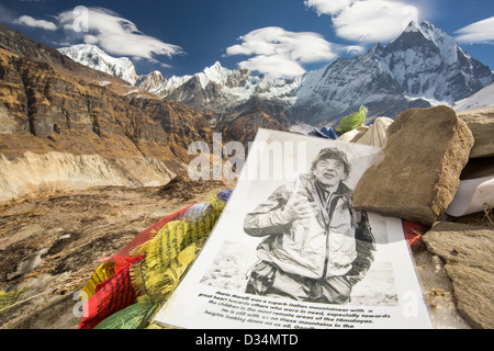 Ein Denkmal für Mario Merelli, ein italienischer Kletterer am Annapurna Annapurna Basislager 4130 m getötet Annapurna Sanctuary, Himalaya, Nepal. Im Hintergrund ist ein klaffenden Abgrund links vom Annapurna South Gletscher, die aufgrund des Klimawandels massiv zurückgegangen ist. Stockfoto