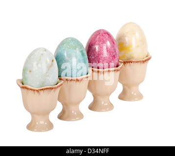 Ostereier in Eierbecher isoliert über weißen Marmor Stockfoto