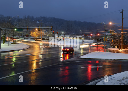 Stadt-Kreuzung im Winter mit nassen Straßen & Schnee Stockfoto