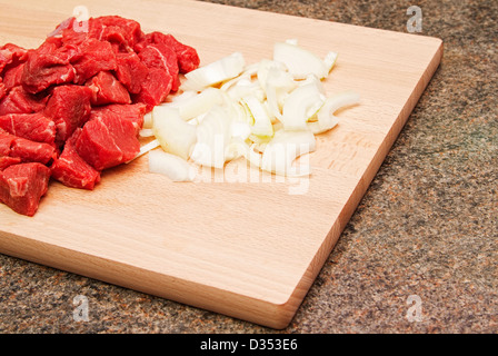 Gehacktes Rindfleischsteak und Zwiebeln auf Holzbrett Stockfoto