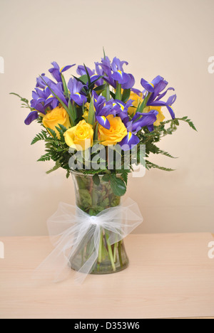 Vase mit gelben Rosen und lila Schwertlilien Stockfoto