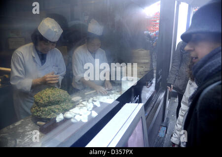 London, 10. Februar 2013. Dämpfen Sie weht von einem Restaurant in Chinatown, wie Köche Knödel in ein Fenster vor Passanten zu machen, um das chinesische Neujahr zu feiern. Dies ist das Jahr der Schlange.  Tausende von Menschen säumten die Straßen, um Se die bunte Parade und Probe chinesisches Essen trotz des nasskalten Wetters. Stockfoto