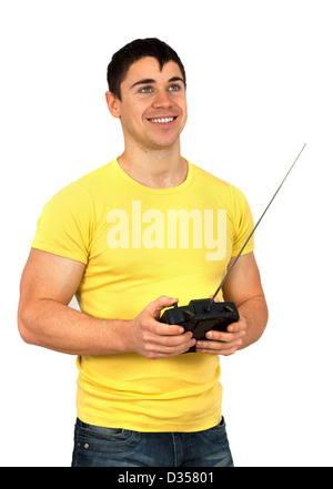 Junger sportlicher Mann hält eine Funk-Fernbedienung (controlling Mobilteil) für Hubschrauber oder Flugzeug. Isoliert auf weißem Hintergrund Stockfoto
