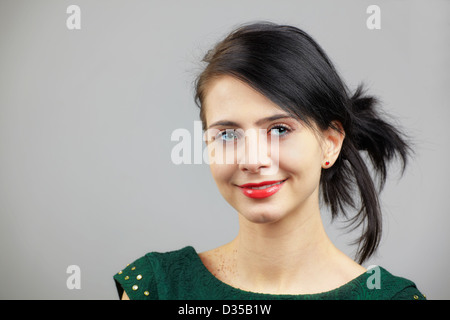 Porträt einer schönen jungen Frau isoliert auf grau. Stockfoto