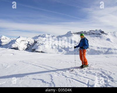 Männlichen Skifahrer Skifahren im Skigebiet Le Grand Massif mit Blick auf schneebedeckte Berge in den französischen Alpen. Flaine, Rhone-Alpes, Frankreich Stockfoto