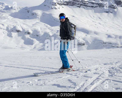 Männlichen Skifahrer Skifahren im Skigebiet Le Grand Massif mit Blick auf schneebedeckte Berge in den französischen Alpen. Flaine, Rhone-Alpes, Frankreich Stockfoto