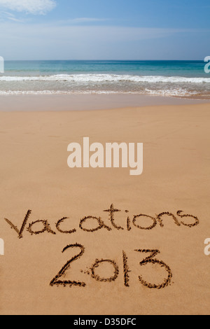 Worte "Ferien 2013" geschrieben in Sand am tropischen Strand Stockfoto