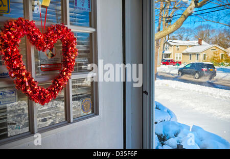 9. Februar 2013 - Merrick, New York, USA - nach Blizzard Nemo auf Long Island South Shore Gemeinschaften, Autos fahren durch matschigen Gepflügtes Straßen, wie gesehen von Haustür des Hauses verziert mit roten Herzen zum Valentinstag ist ein paar Tage weg. Stockfoto