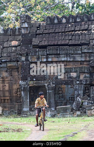 Junge auf Fahrrad reitet durch Wat Nokor, einem 11. Jahrhundert Tempel in Kompong Cham, Kambodscha. Stockfoto