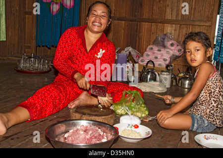 Junge Frau bereitet Schweinefleisch, Knoblauch und Gemüse für das Abendessen auf der Insel Koh Trong über den Mekong River von Kratie, Kambodscha. Stockfoto