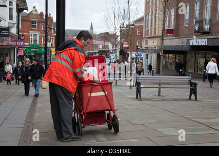 Royal Mail Besetzungen, Postmann und Post Delivery; die Geschäfte und Straßen der Lancashire Stadt Wigan, Großbritannien Stockfoto