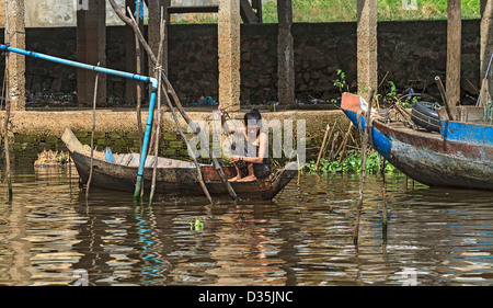 Frau fängt Fisch in Kompong Plu, ka Gruppe von drei Stelzen-Haus-Dörfer in der Nähe von Siem Reap, Kambodscha Stockfoto