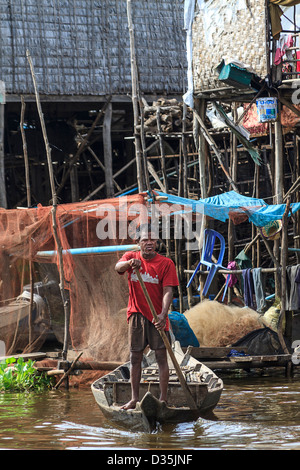 Mann fährt auf kleinen Boot in Kompong Pluk (Phluk), eine Gruppe von drei Stelzen-Haus-Dörfer in der Nähe von Siem Reap, Kambodscha Stockfoto