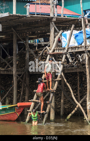 Kinder spielen im Wasser von Kompong Pluk (Phluk), eine Gruppe von drei Stelzen Haus Dörfer in der Nähe von Siem Reap, Kambodscha Stockfoto