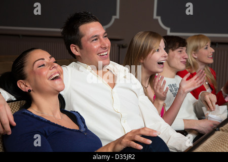 Lachende Menschen in einem Kino oder Theater, die gerade einen Film oder ein Spiel Stockfoto