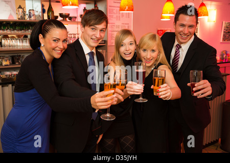 Eine Gruppe von fünf Freunden in einer Bar feiern und posieren für die Kamera Stockfoto