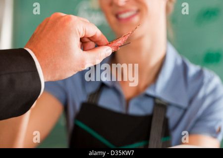 Männlichen Kunden eine Stück Fleisch vom Metzger bei Metzgerei Stockfoto