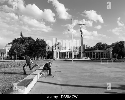 Junge auf Skateboard und Geschäftsmann mit mobile Stockfoto