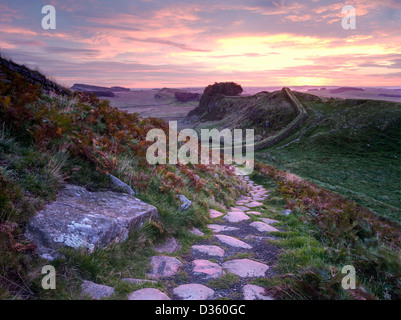 Der Roman Wall bei Sonnenaufgang mit Blick auf die aufgehende Sonne im Osten nahe Housesteads Roman Fort in Northumberland Stockfoto