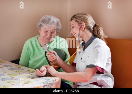 Krankenschwester misst den Blutdruck eines Patienten Stockfoto