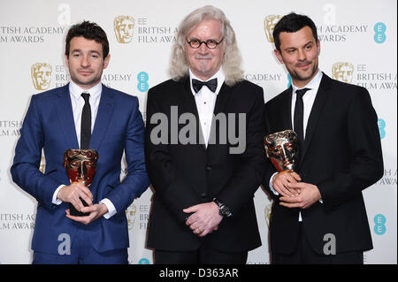 London, UK. 10. Februar 2013. Posieren Sie Bart Layton und Dimitri Doganis, Gewinner des Award herausragende Debüt von A britischer Schriftsteller, Regisseur oder Produzent, mit Moderator Billy Connolly im Presseraum an der EE British Academy Film Awards am Royal Opera House am 10. Februar 2013 in London, England. Bildnachweis: London Entertainment/Alamy Live-Nachrichten Stockfoto