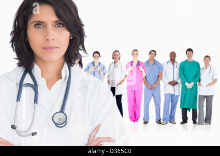 Frau Doktor stehend Arme gekreuzt vor ihrem team Stockfoto