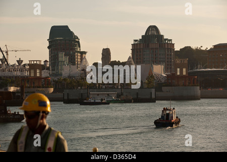 Ein Migrant Arbeiter auf einer Baustelle mit Resorts World Sentosa in Singapur im Hintergrund 2010 Stockfoto