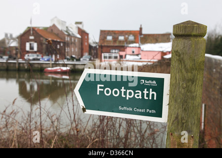 Ein Wanderweg-Zeichen auf der Suffolk Coast Path mit Snape Maltings im Hintergrund Stockfoto